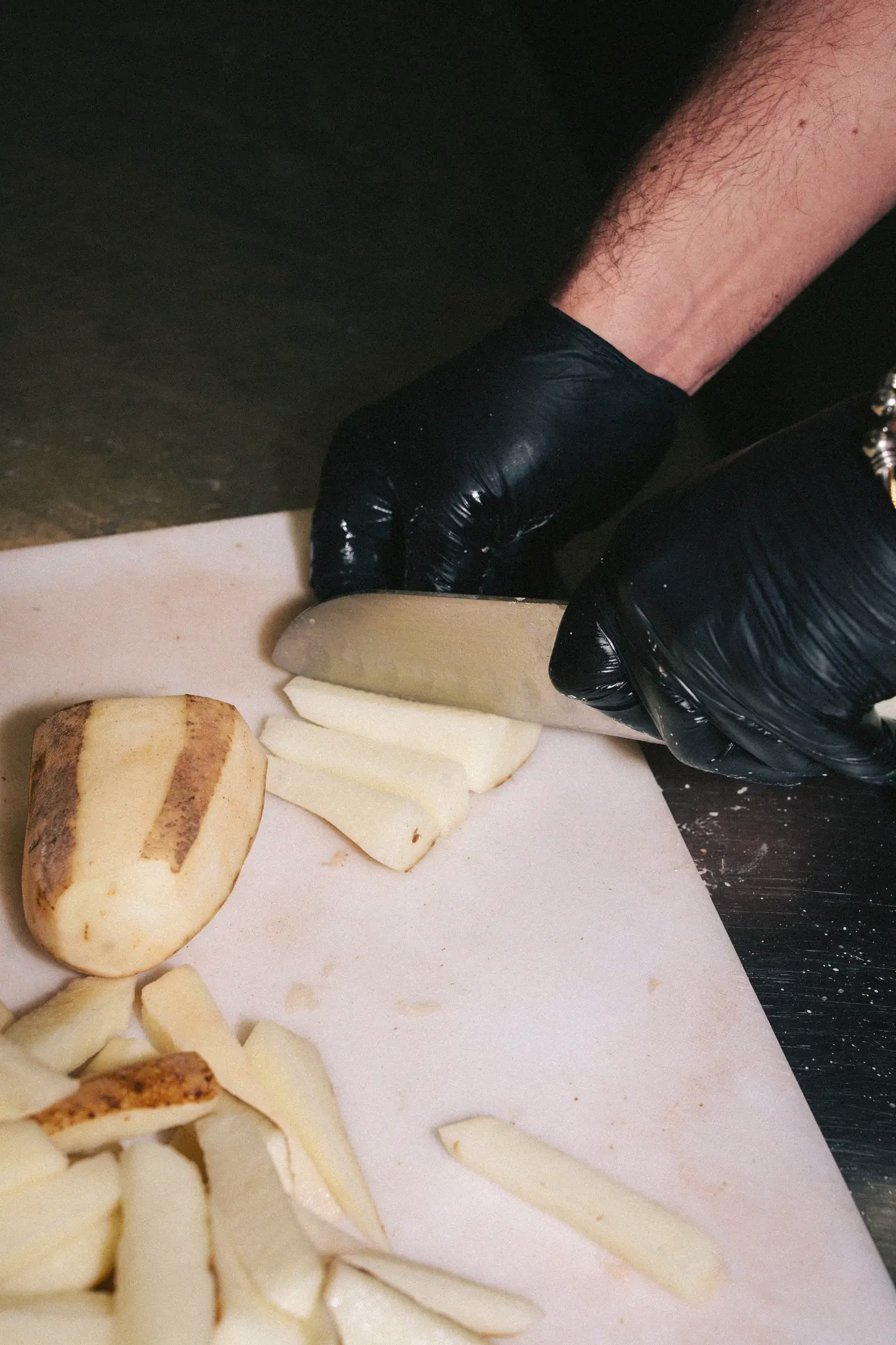 Chef hand-cutting fresh potatoes into Dutch-style fries at FRIES B4 GUYS in Allston, Boston